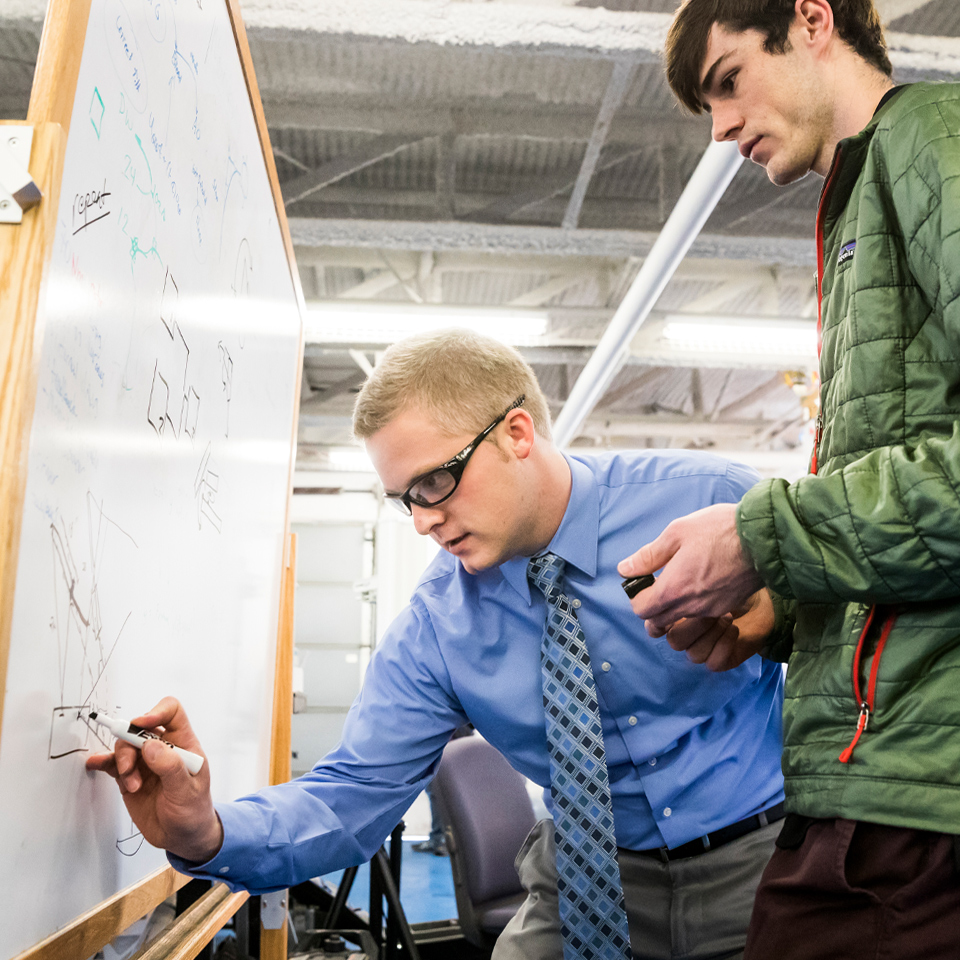 male participants writing on a whiteboard